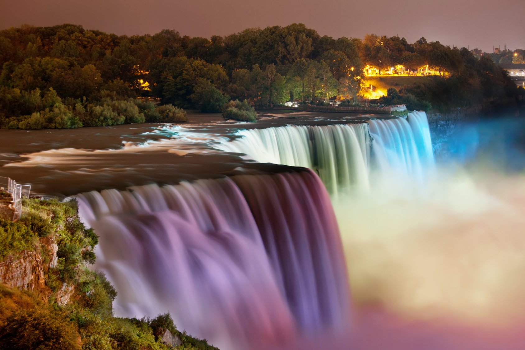 Niagara Falls lit at night by colorful lights