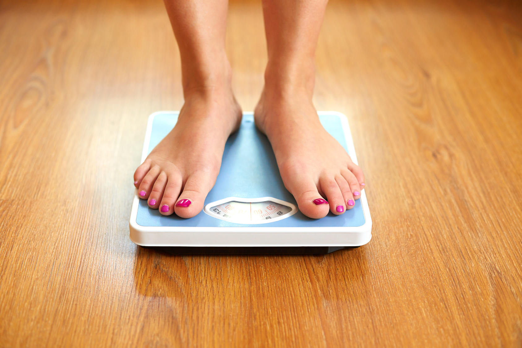 Female bare feet with weight scale