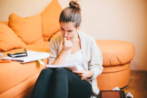 Young woman studying and biting her nails