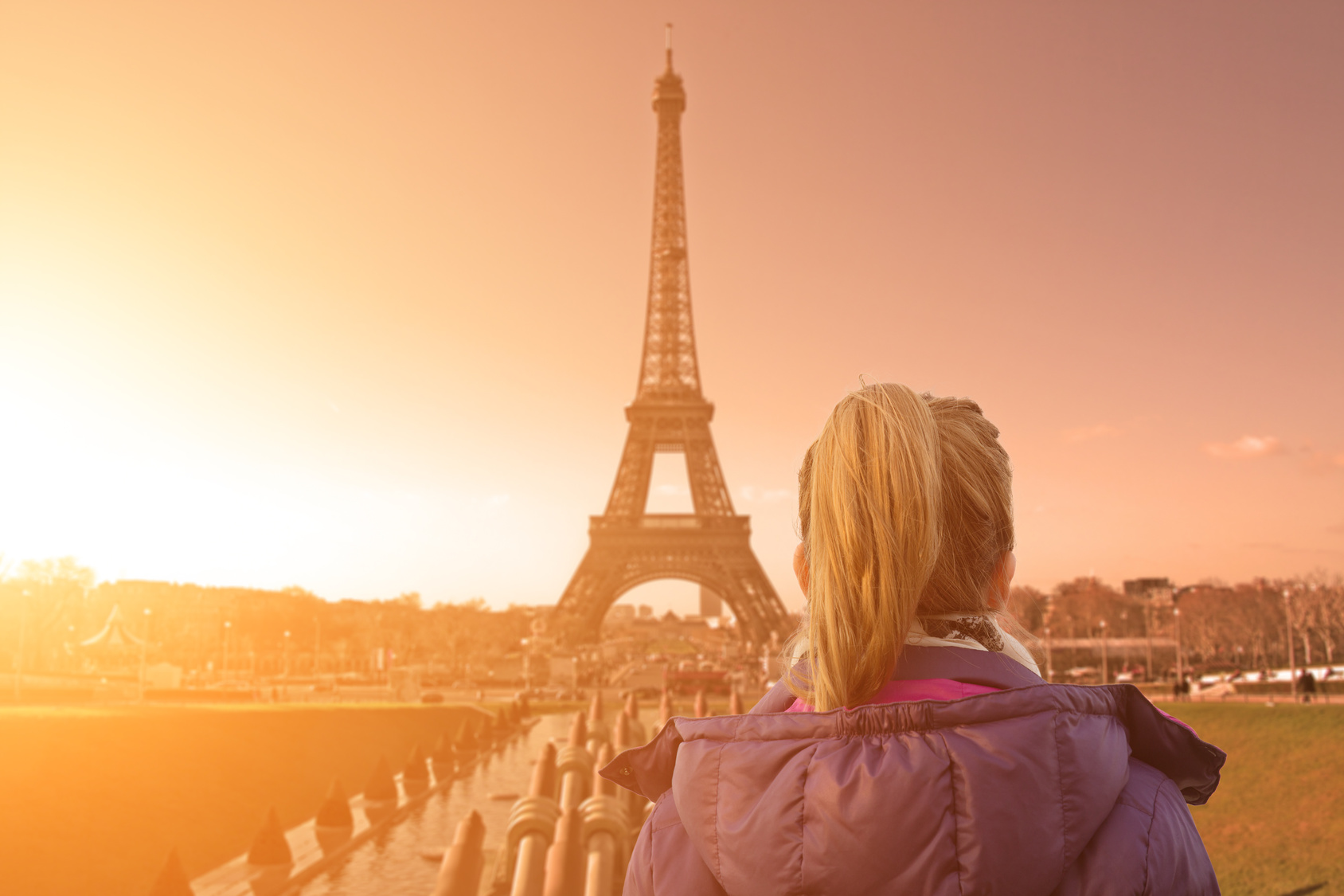 Lonesome girl watching at Paris city scape at sunset/sunrise.
