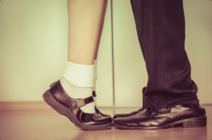 A couple with a different age and hight is kissing eac