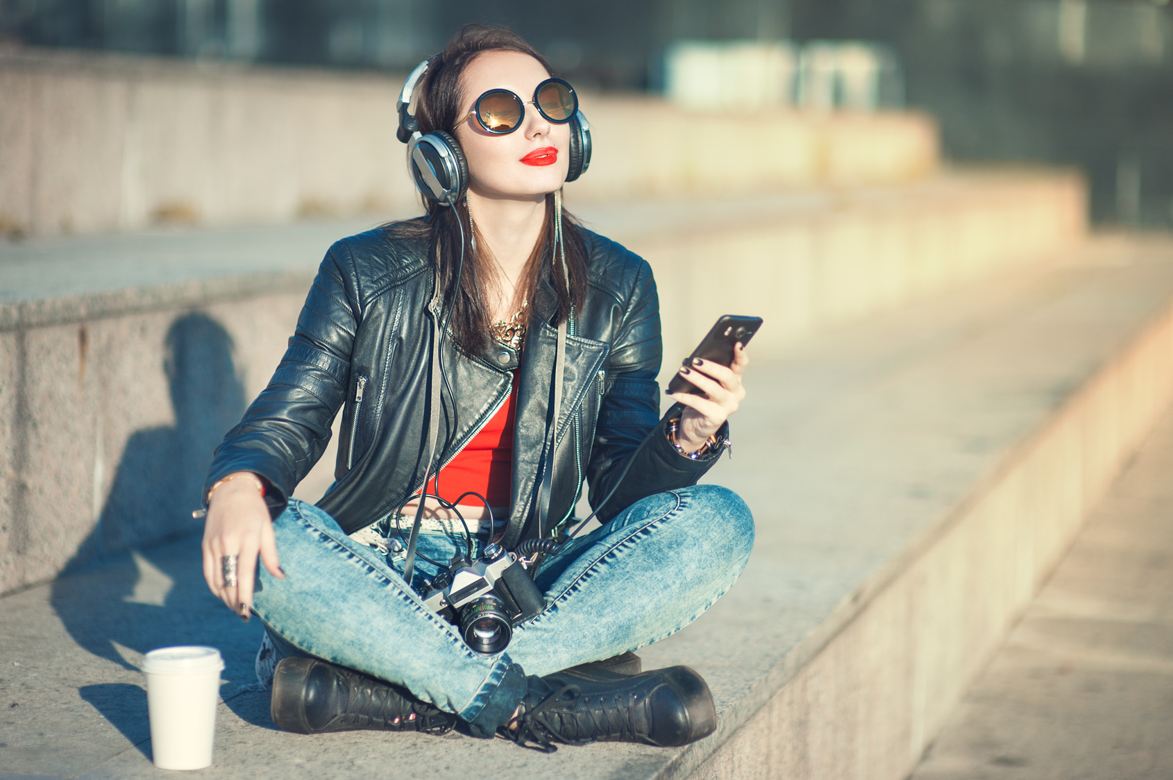 Hipster beautiful girl in leather jacket listening music