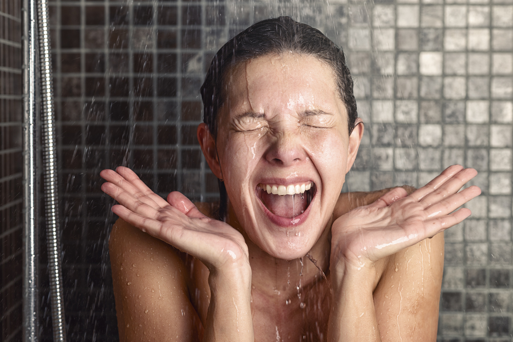Junge Frau reagiert überrascht auf heißes oder kaltes Wasser