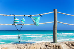 Blue woman’s swimming suit hanging on white ropes