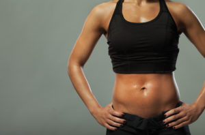 Muscular female body with sweat.