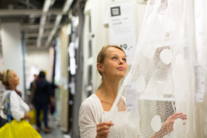 Pretty, young woman choosing the right curtains
