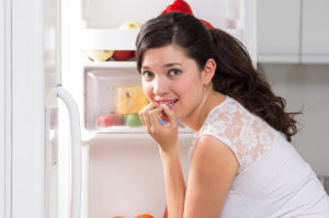 young beautiful woman searching for food in the fridge