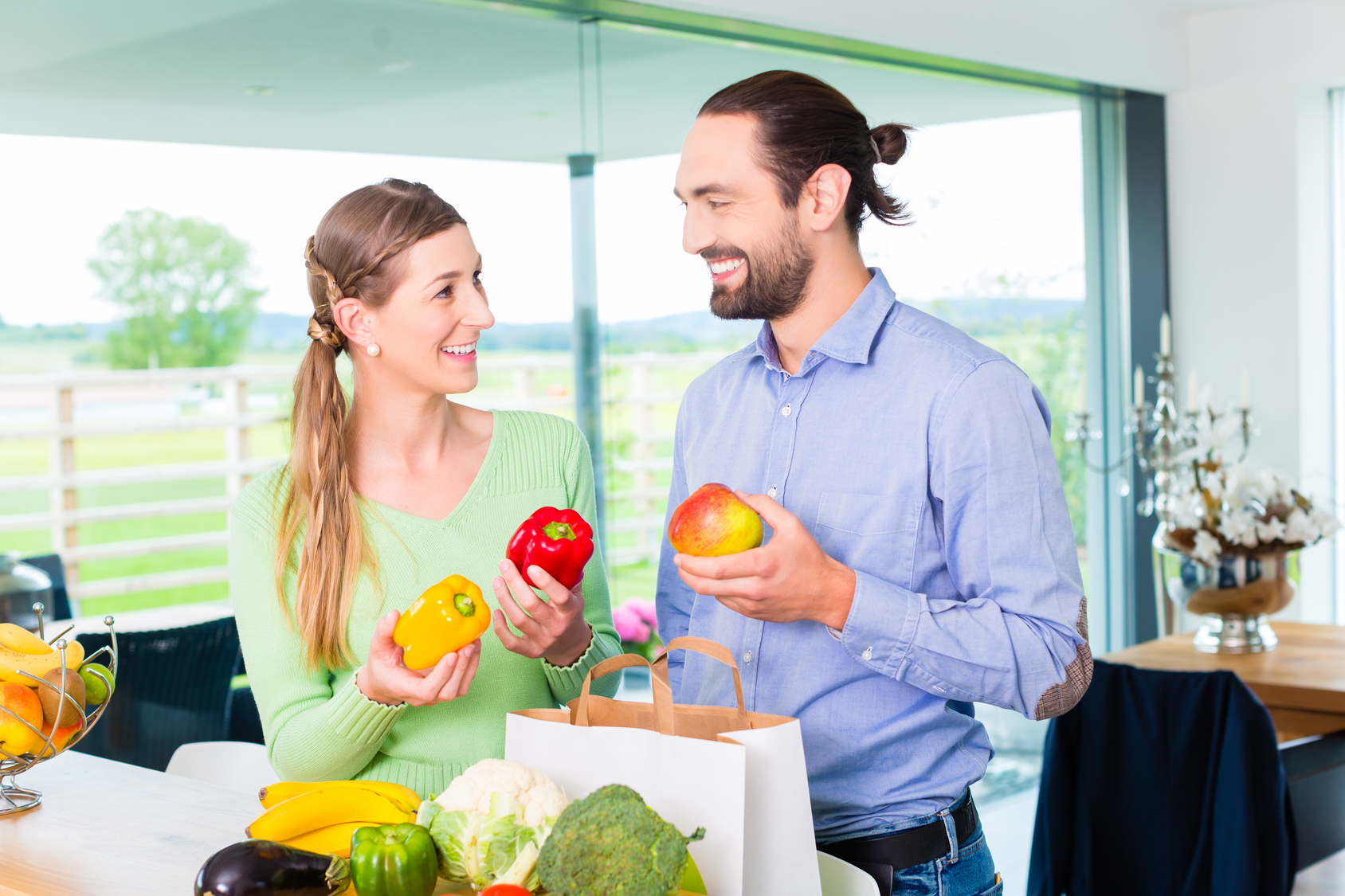 Couple unpacking grocery shopping bag at home