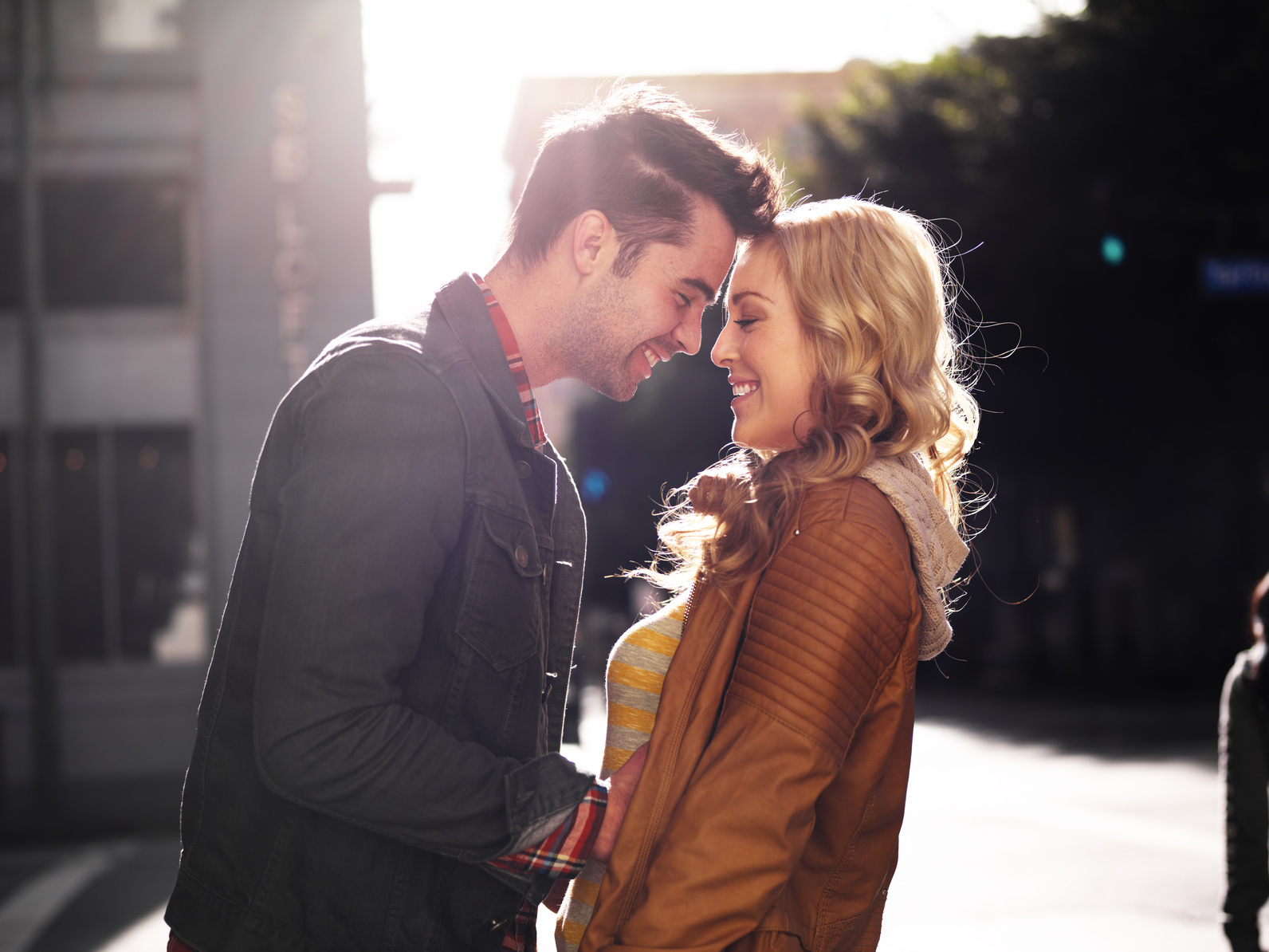 couple on street in city flirting with lens flare