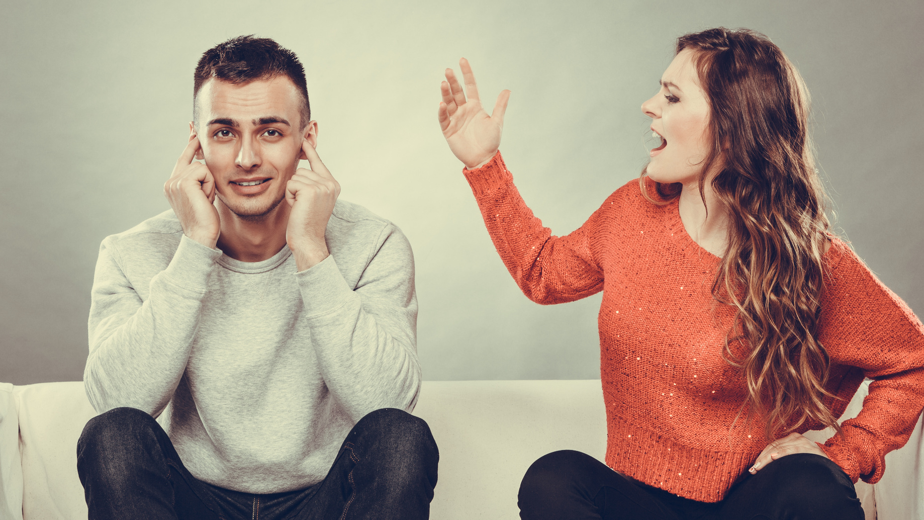 Angry fury woman screaming man closes his ears.