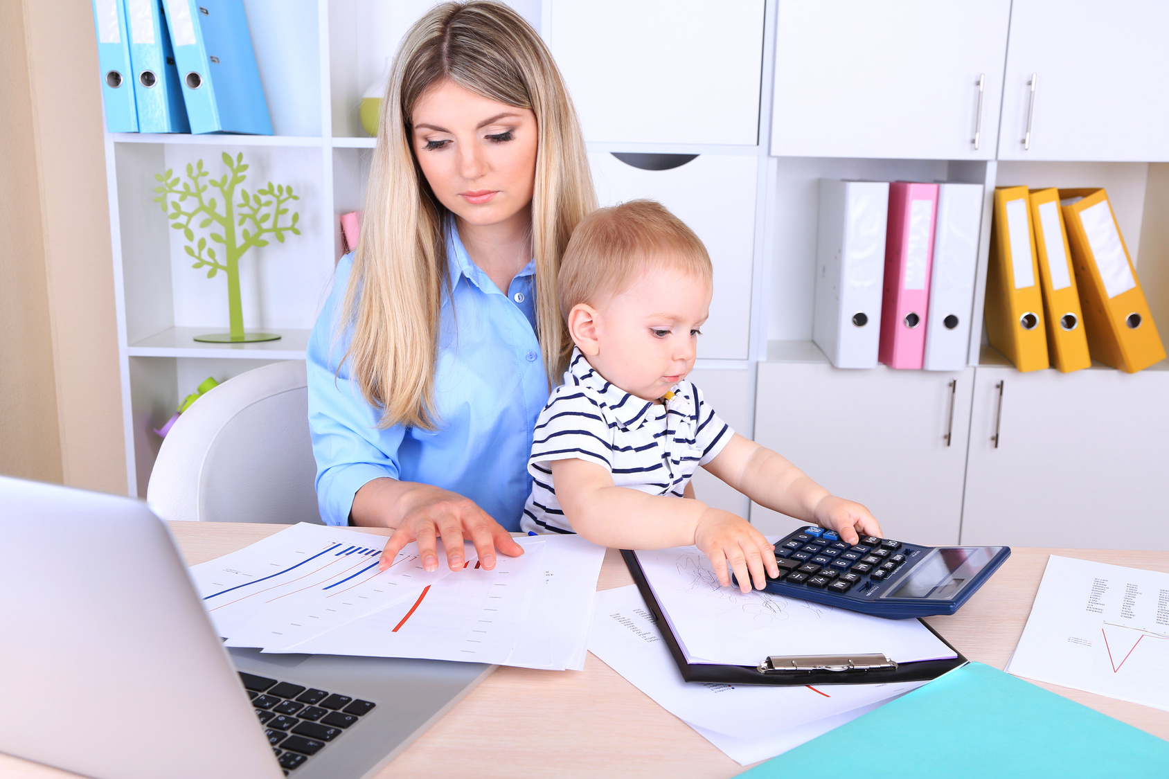 Pretty woman with baby working at home