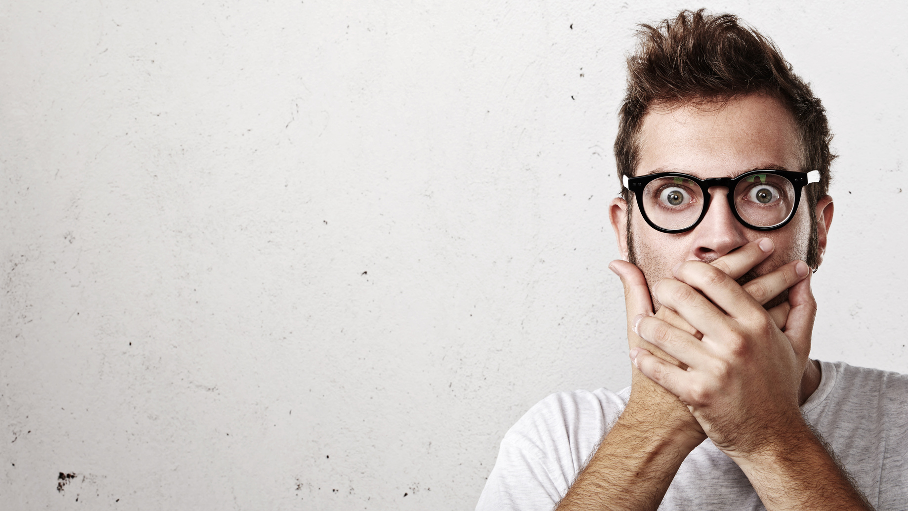 Shocked man covering his mouth with hands