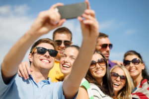 group of friends taking selfie with cell phone