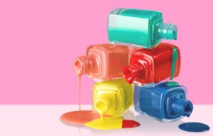 Accessory. Bottles with spilled nail polish over white