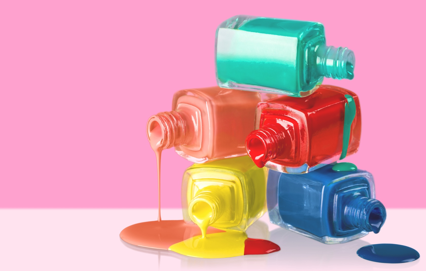 Accessory. Bottles with spilled nail polish over white