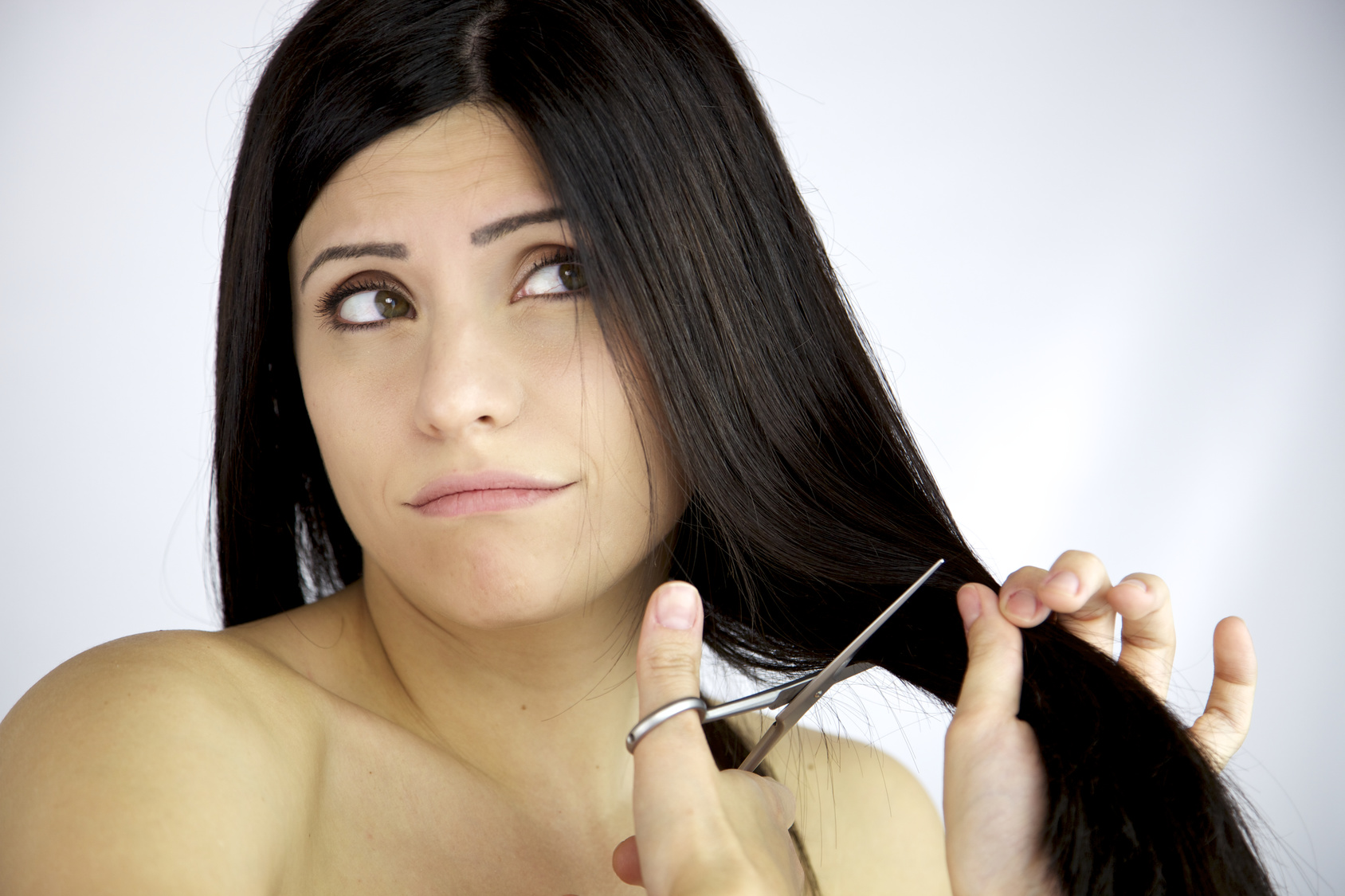 Beautiful female model dubious about cutting her long black hair