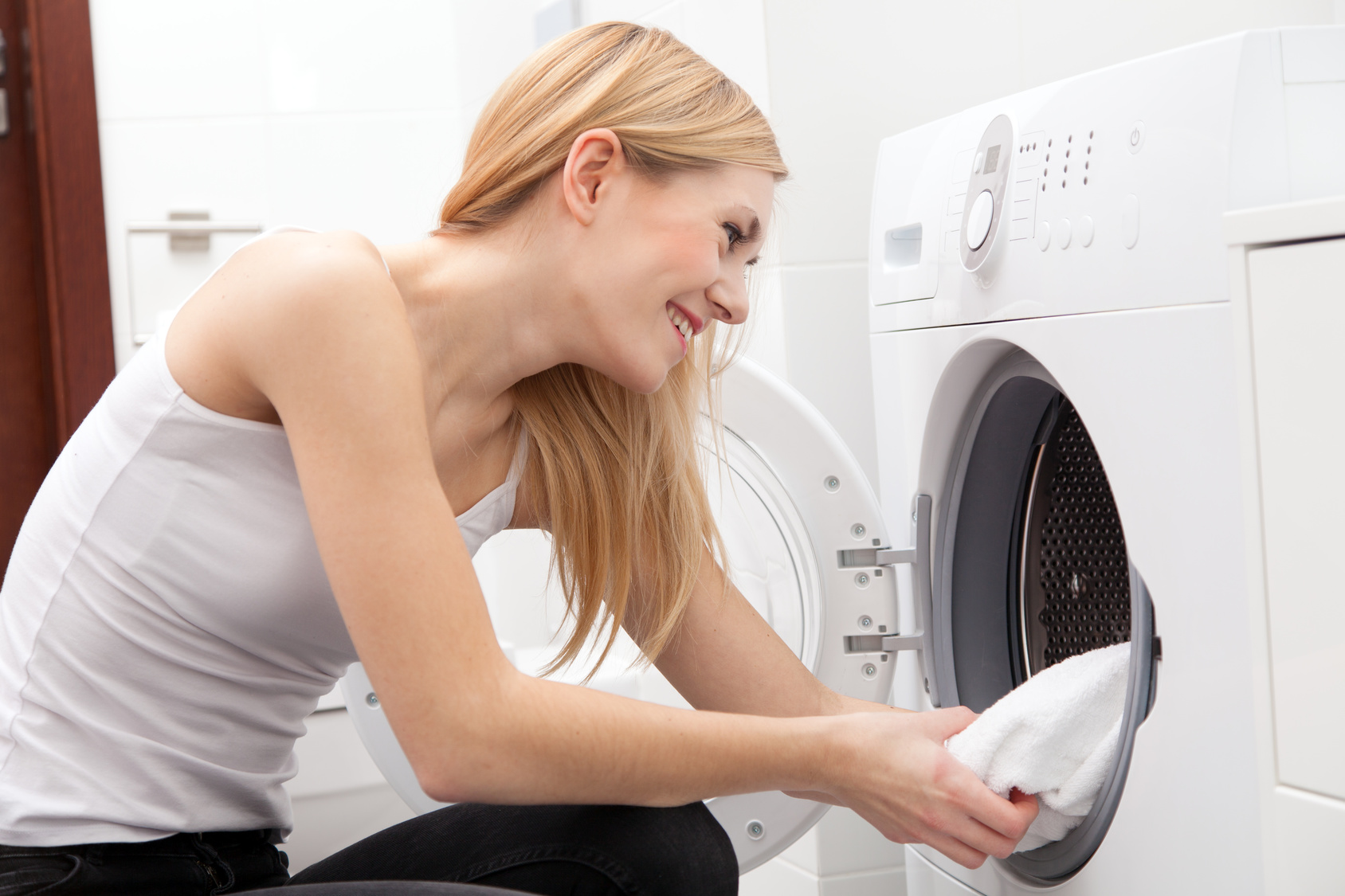 Young beautiful woman using a washing machine