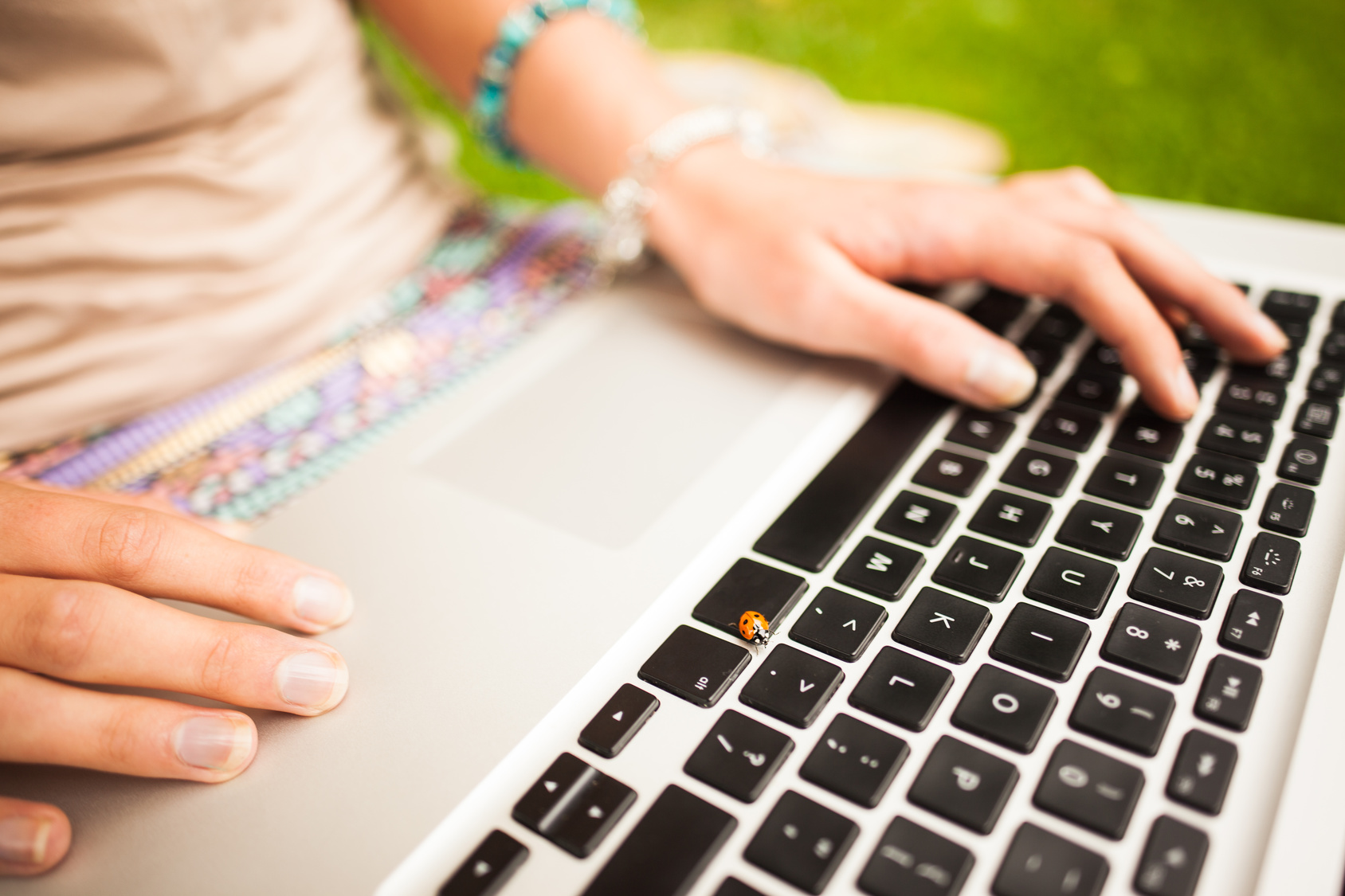 Detail shot of a woman using laptop at the lawn