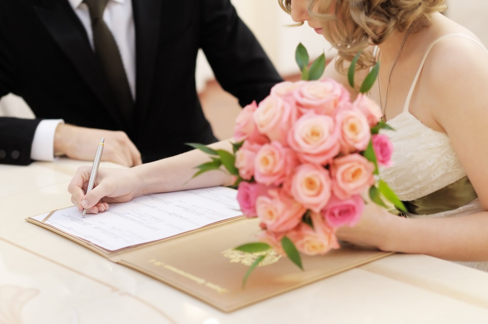 Bride signing marriage license or wedding contract