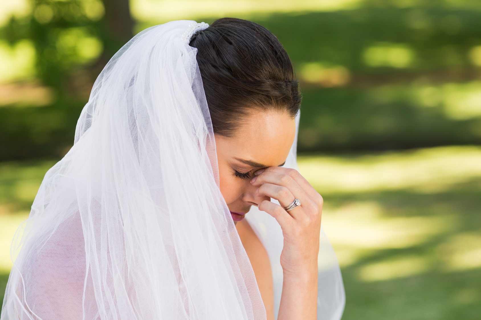 Close-up of beautiful worried bride at park