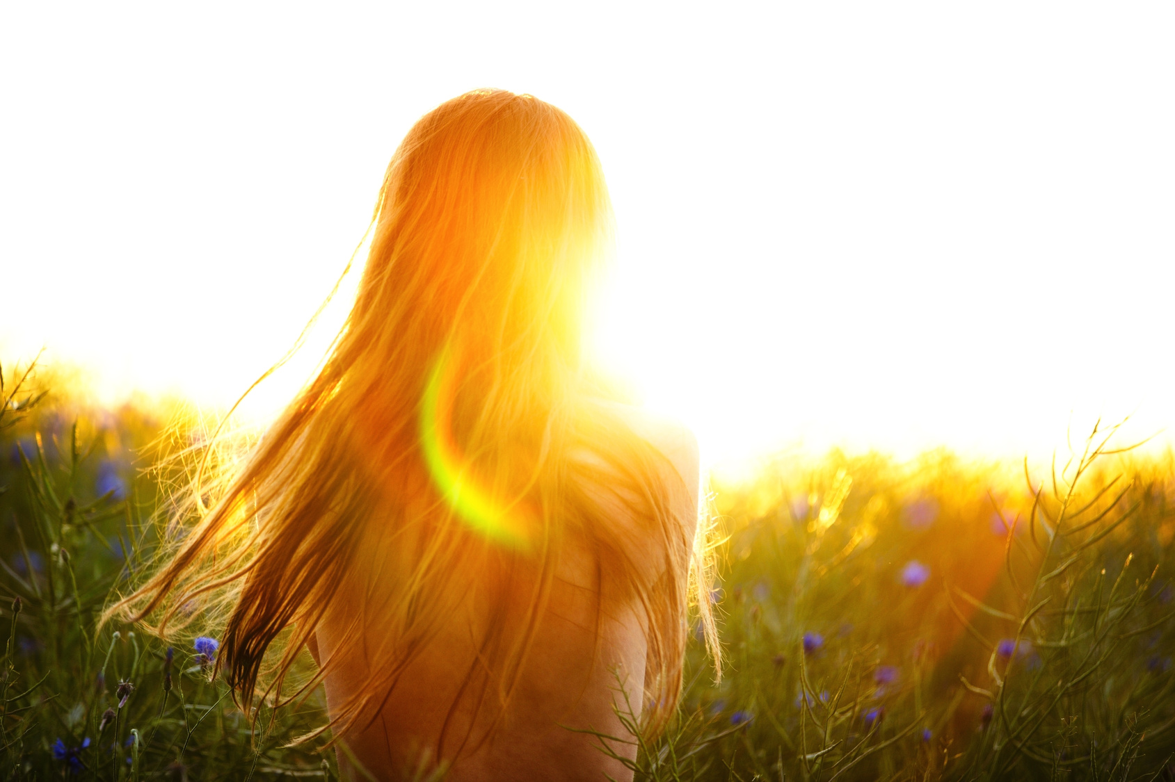 Young woman enjoying sunlight in canola field