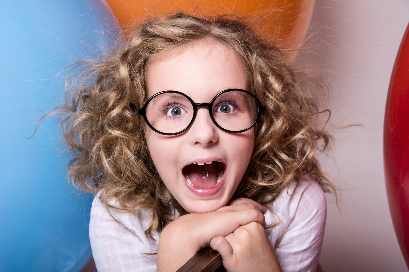Happy surprised girl in glasses with an open mouth