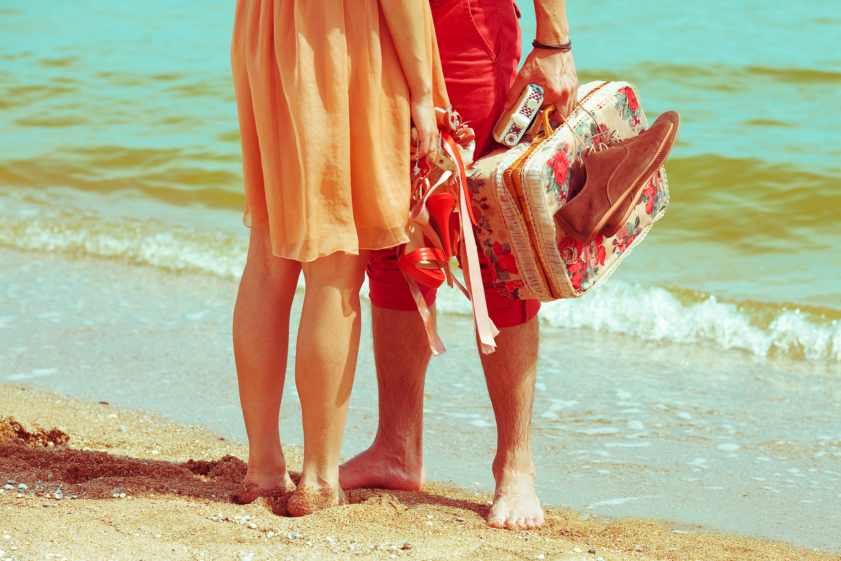 Young married couple standing together on beach