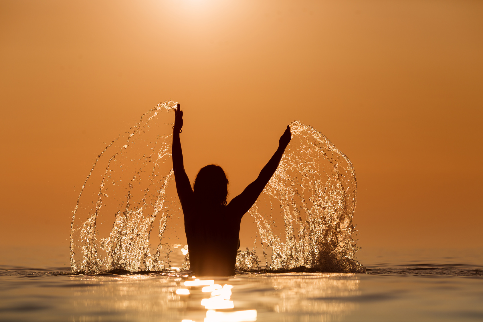 Beauty Model Girl Splashing Water with her hands. Teen girl Swim