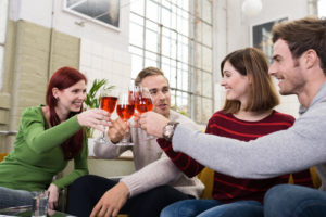 freunde stoen mit rotwein an
