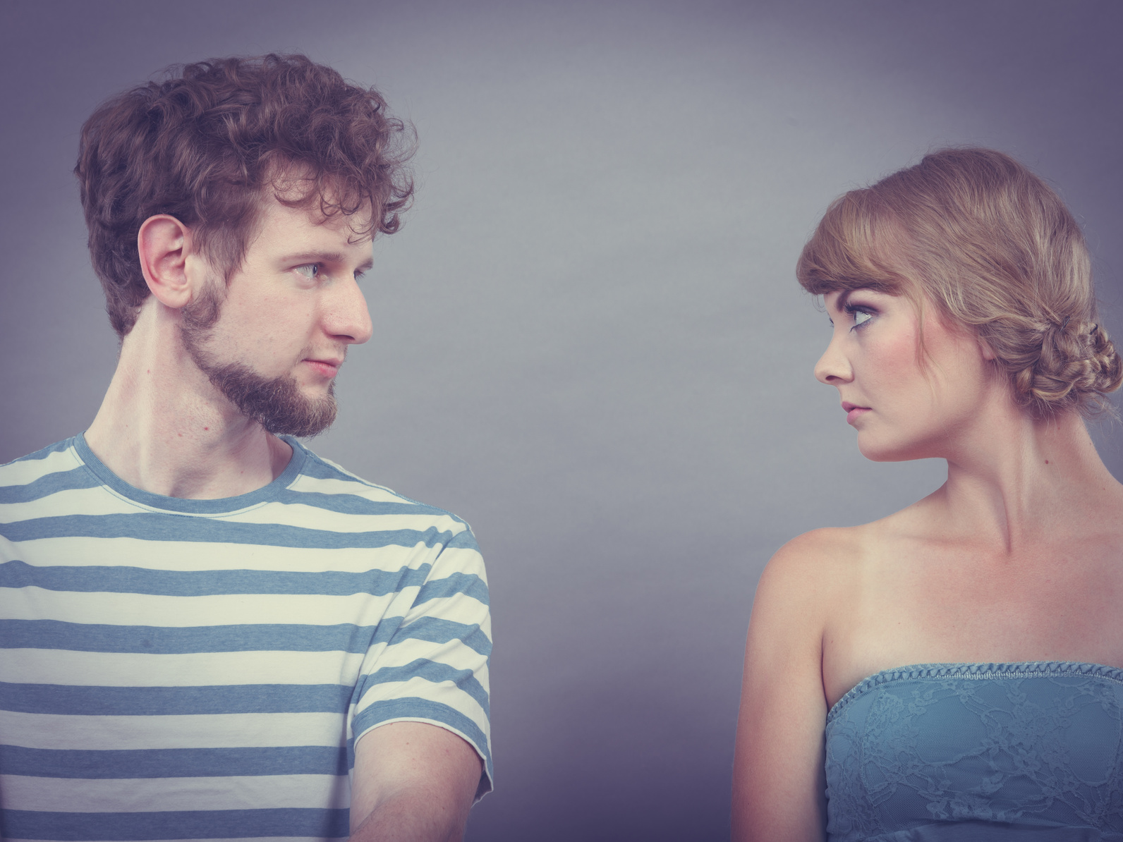 woman and man sitting on sofa looking to each other.