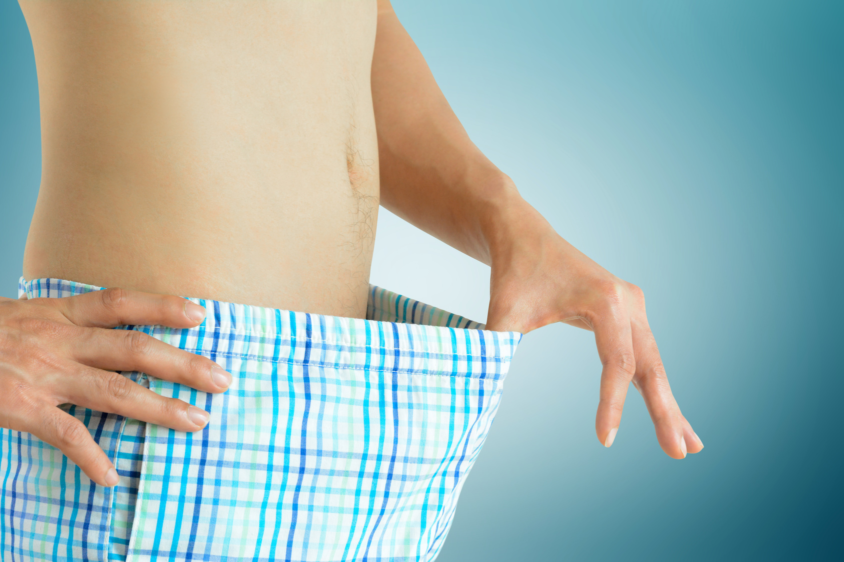 Young man looking inside his boxer shorts