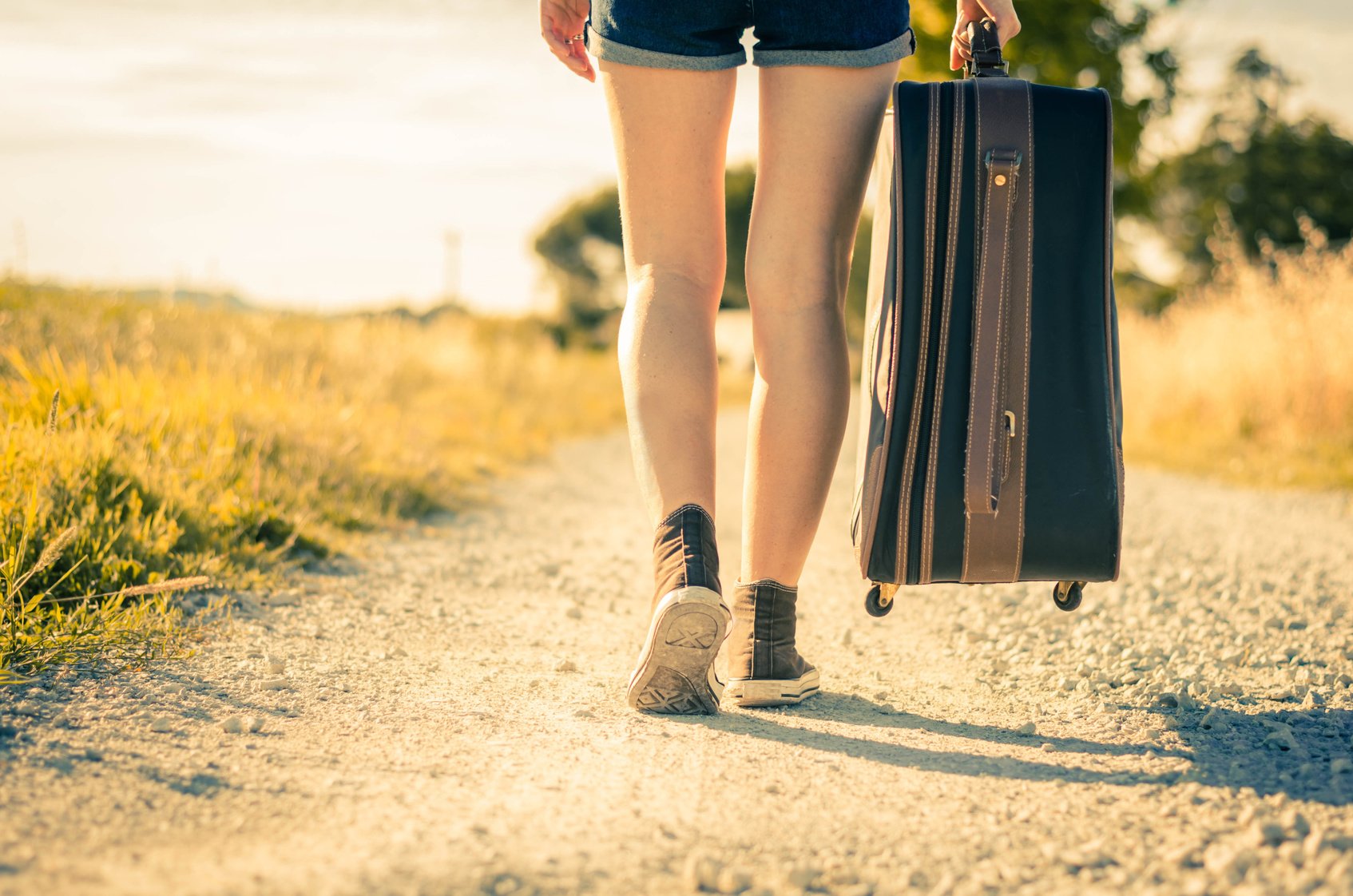 girl walking with her suitcase on vacation – holidays and lifestyle concept