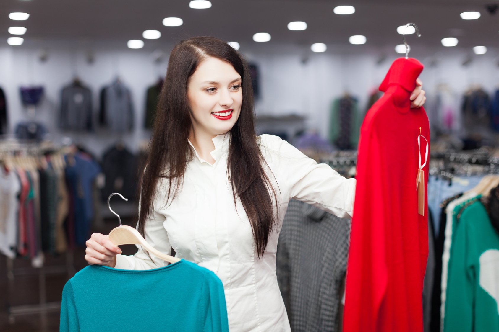 woman choosing sweater at clothing shop