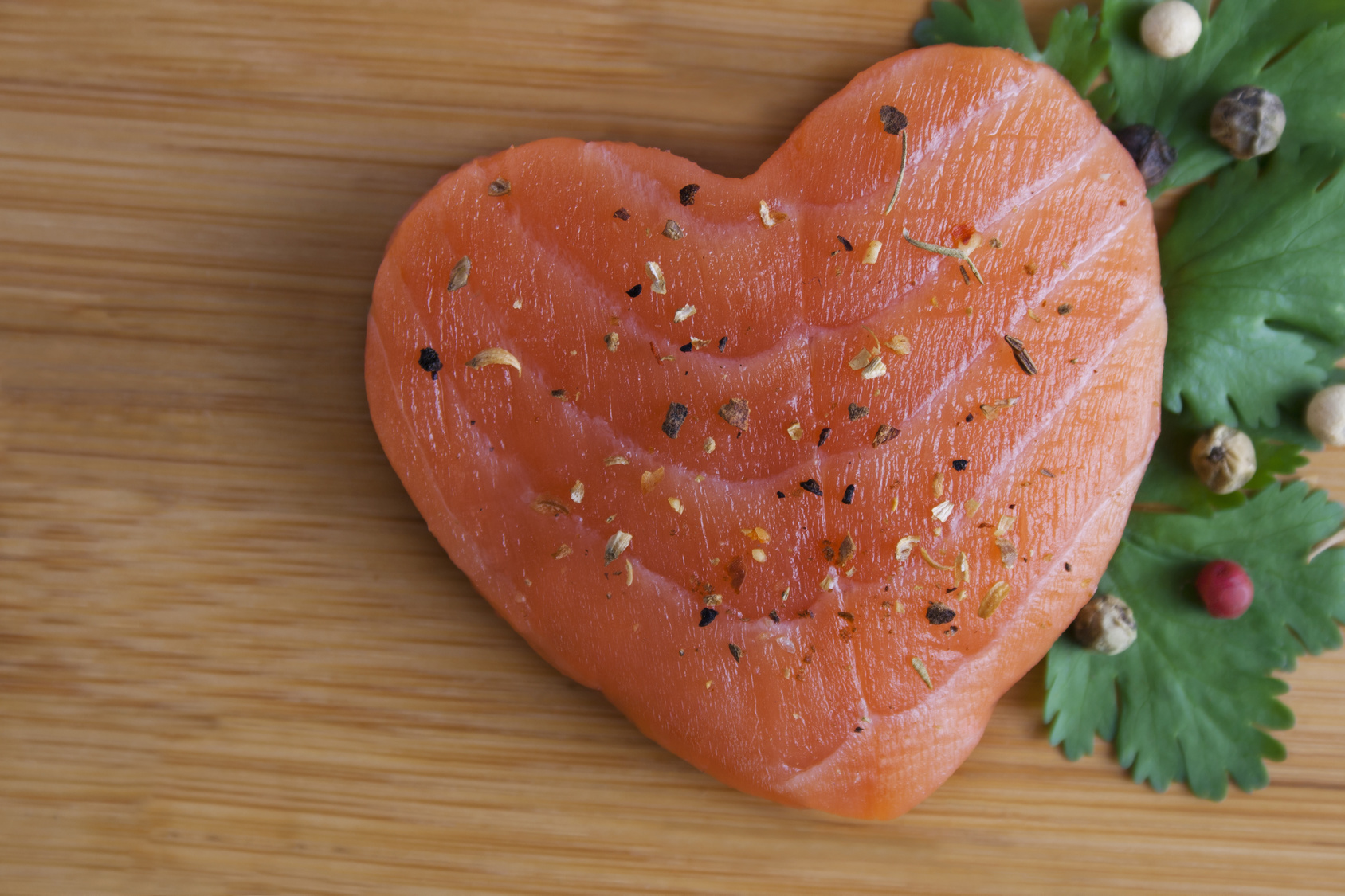 Heart shaped salmon with wooden backgroud