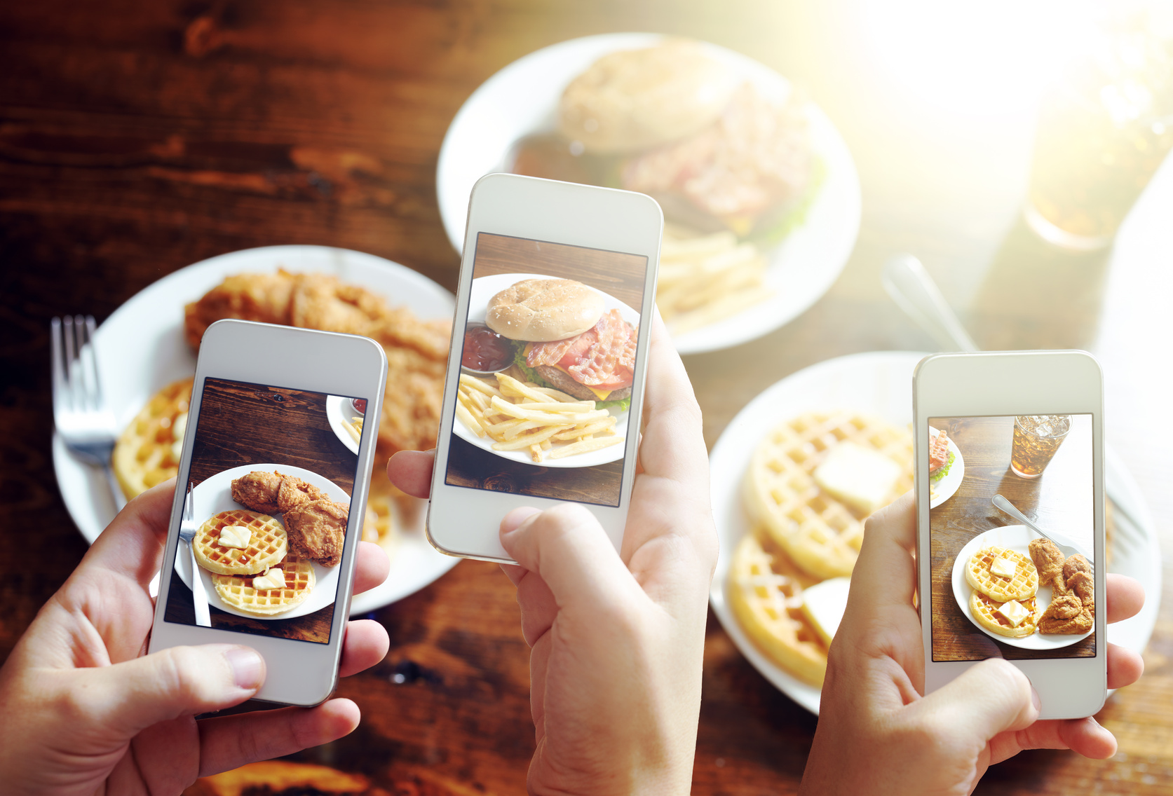 friends using smartphones to take photos of food