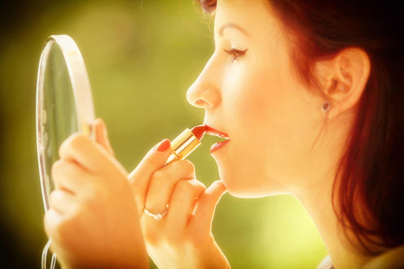 girl retro style applying make up looking at mirror indoor