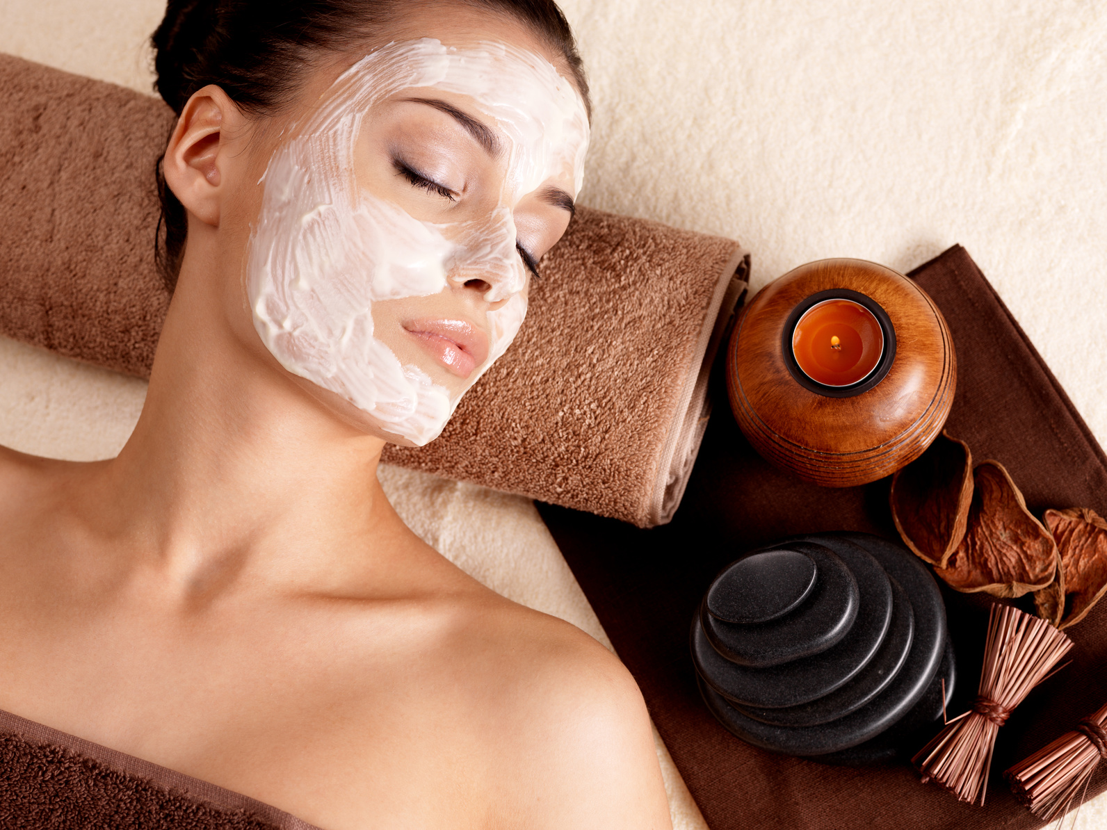 woman relaxing with facial mask on face at beauty salon