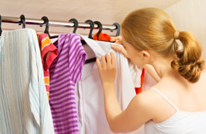 woman chooses clothes in the wardrobe closet at home