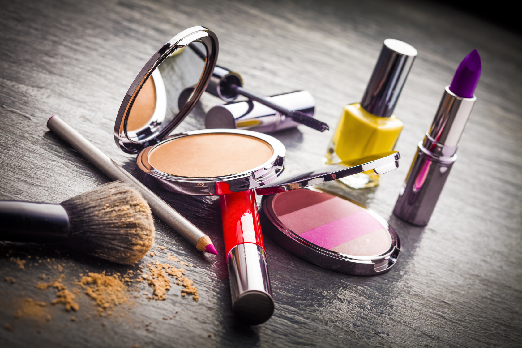 Cosmetics on black slate background