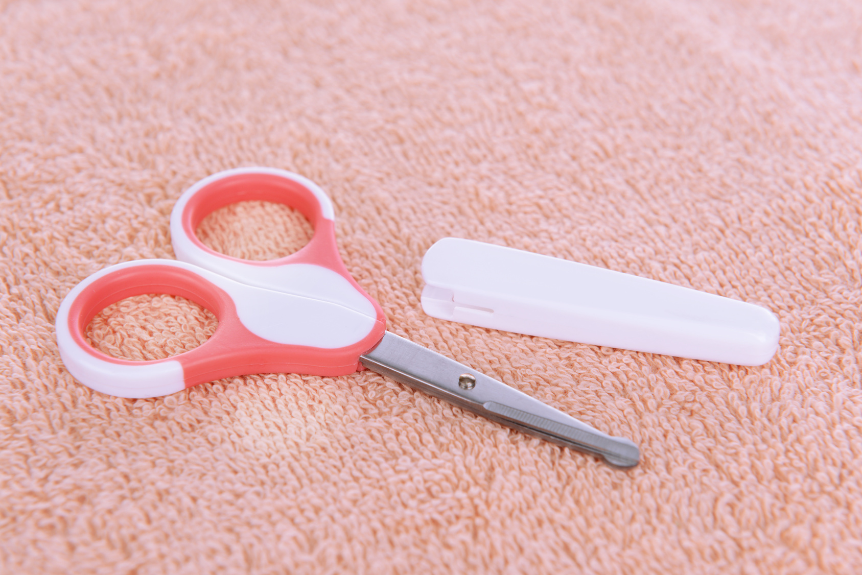 Baby scissors on towel background