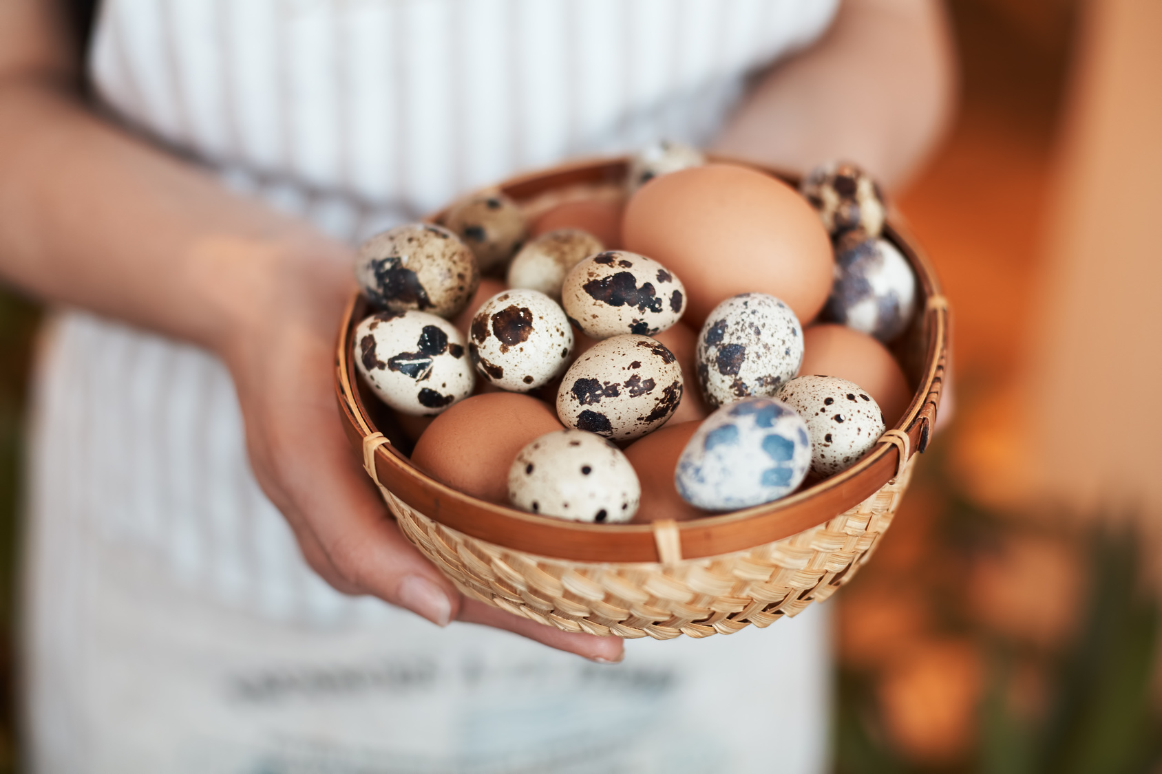 woman in white holding up eggs in basket