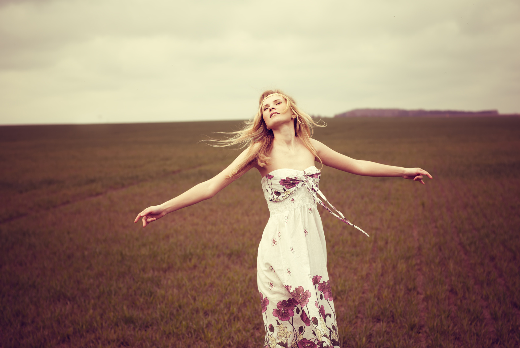 happy beautiful young girl dancing in a field