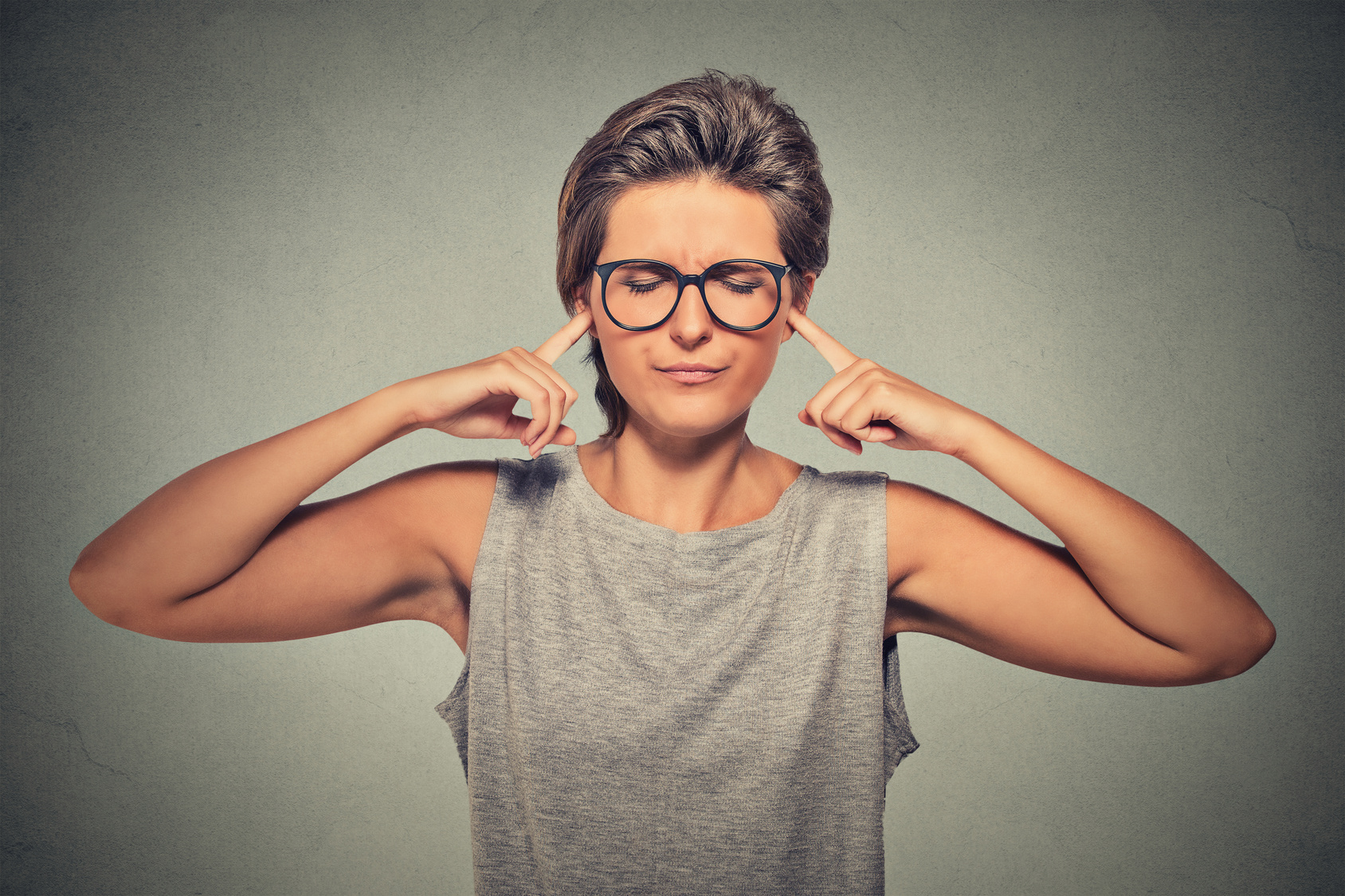 plugging ears with fingers doesn’t want to listen woman hear upset
