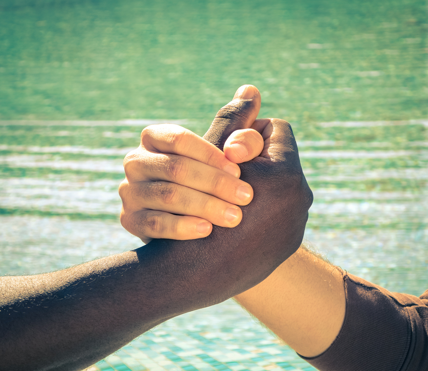 Black and white hands handshake against racism