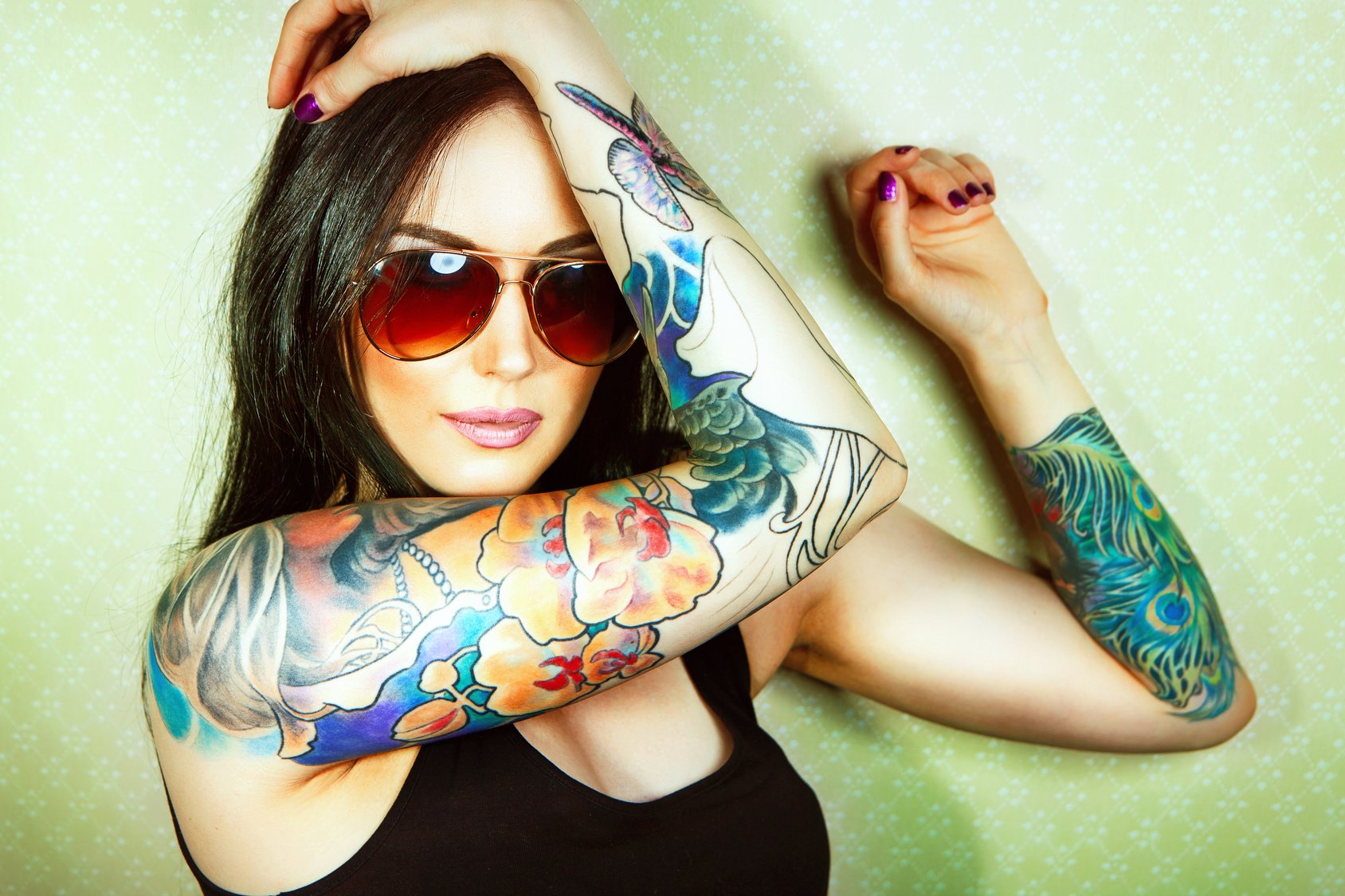 Beautiful girl with stylish make-up and tattooed arms..
