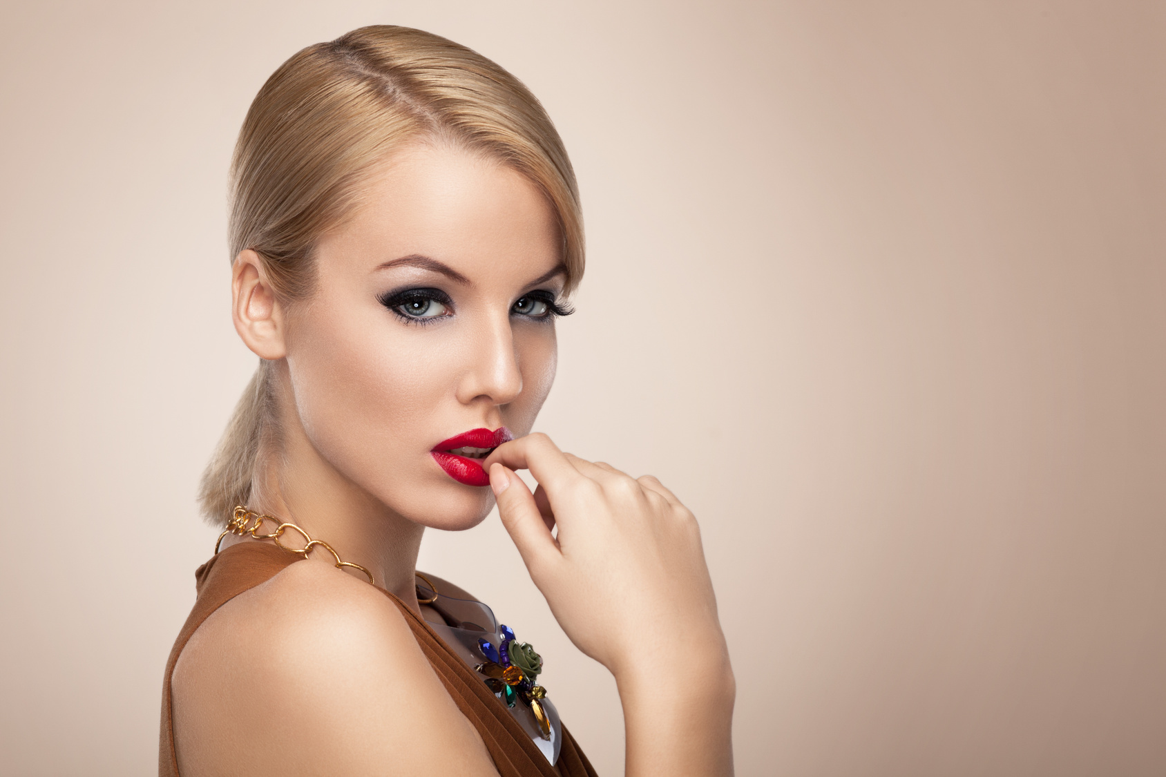 Beautiful blonde with red lipstick posing in the studio