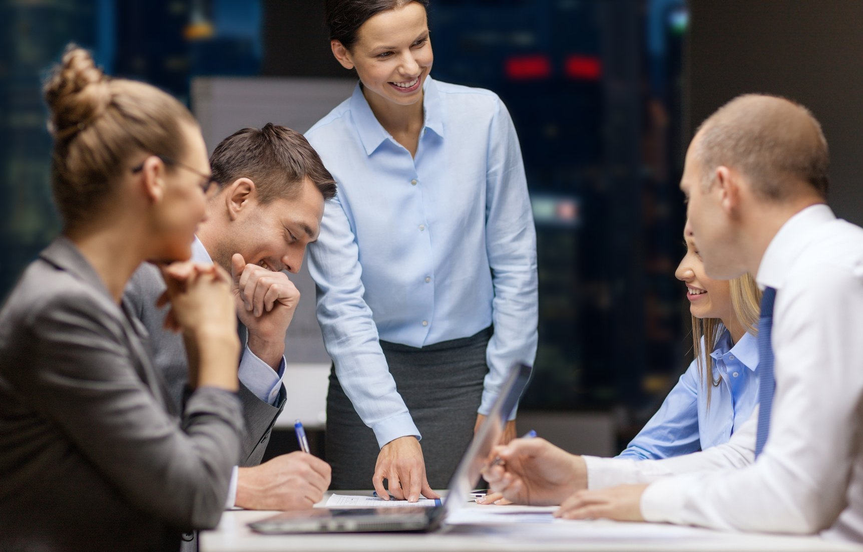 smiling female boss talking to business team