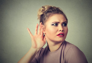 nosy woman hand to ear gesture carefully secretly listen in on gossip conversation