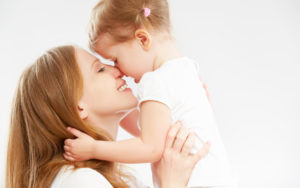 happy family mother and  baby daughter hugging and kissing