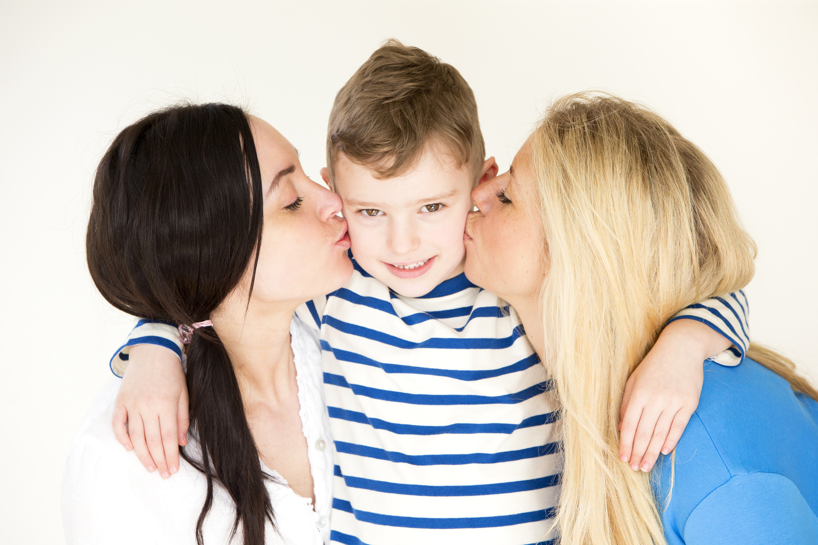 Female couple kissing son’s cheeks